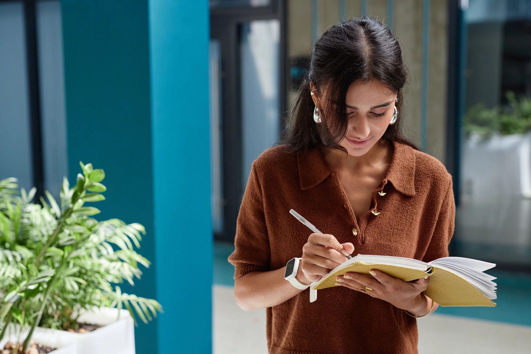 Person taking notes while working on a laptop